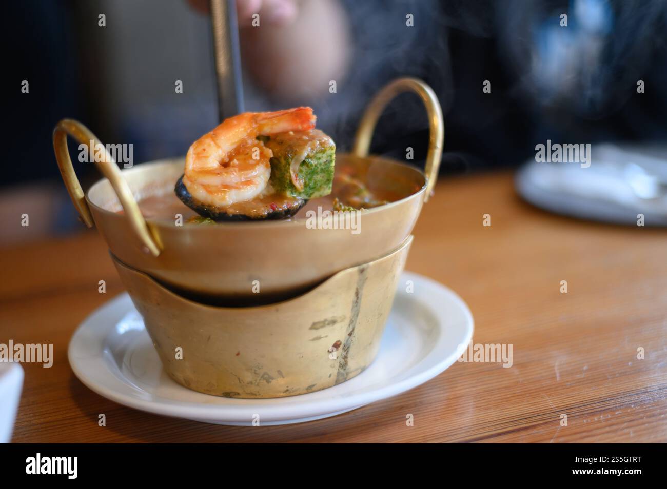 Zuppa acida Cha-om con gamberi nella pentola. Messa a fuoco selettiva. Foto Stock