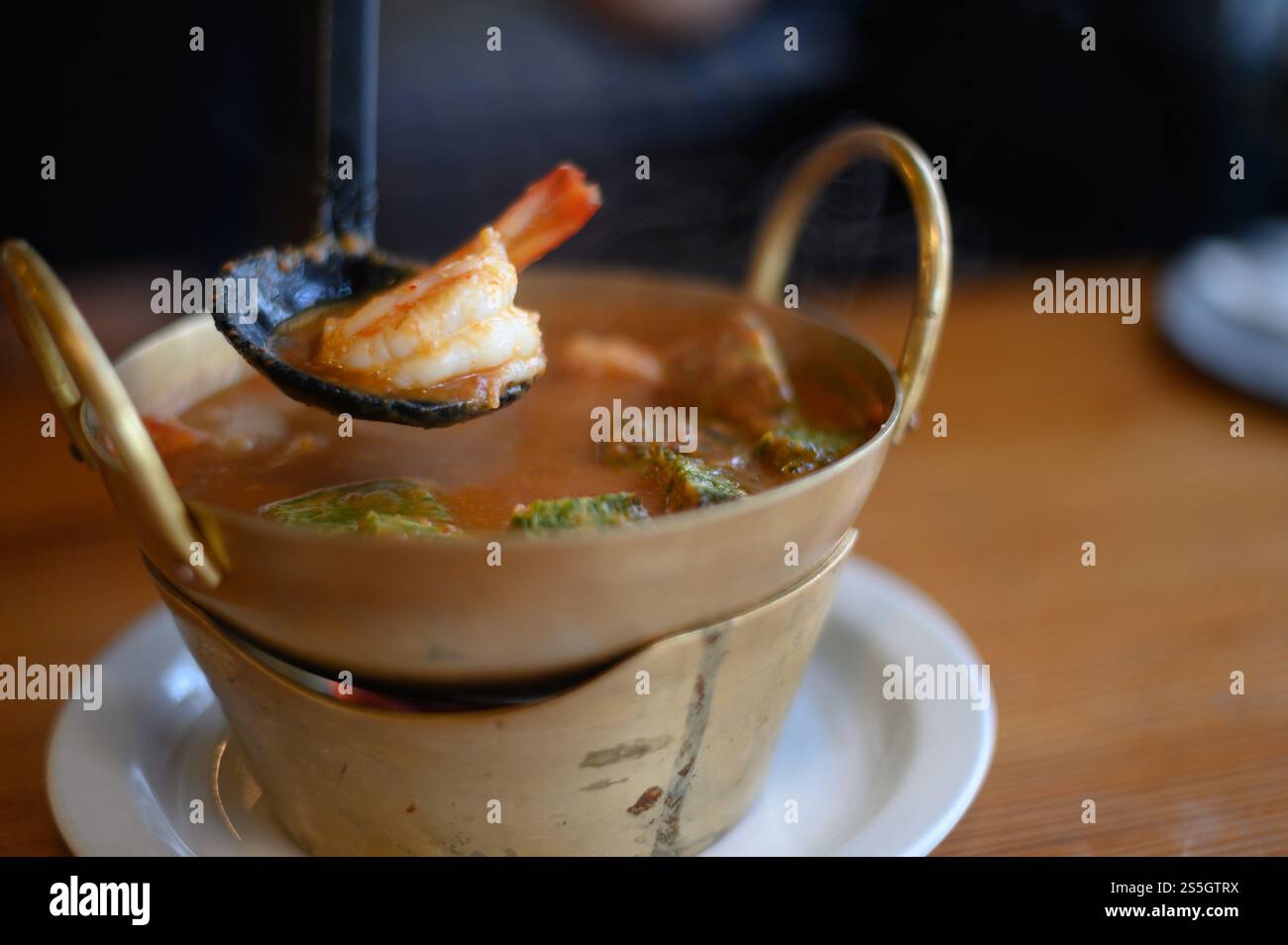 Zuppa acida Cha-om con gamberi nella pentola. Messa a fuoco selettiva. Foto Stock