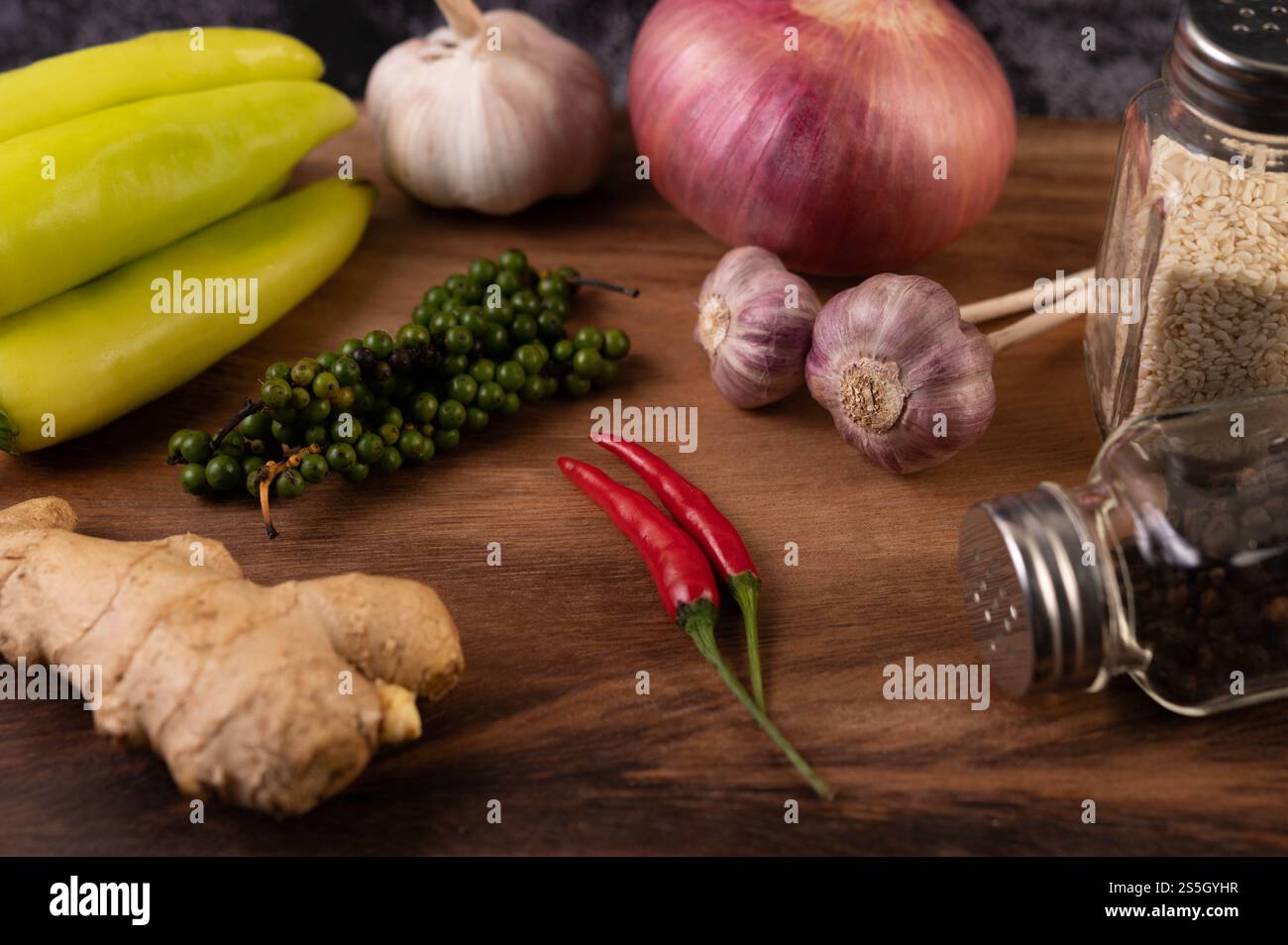 Zenzero, peperoncino, aglio e semi di pepe fresco sul pavimento in legno. Messa a fuoco selettiva. Foto Stock