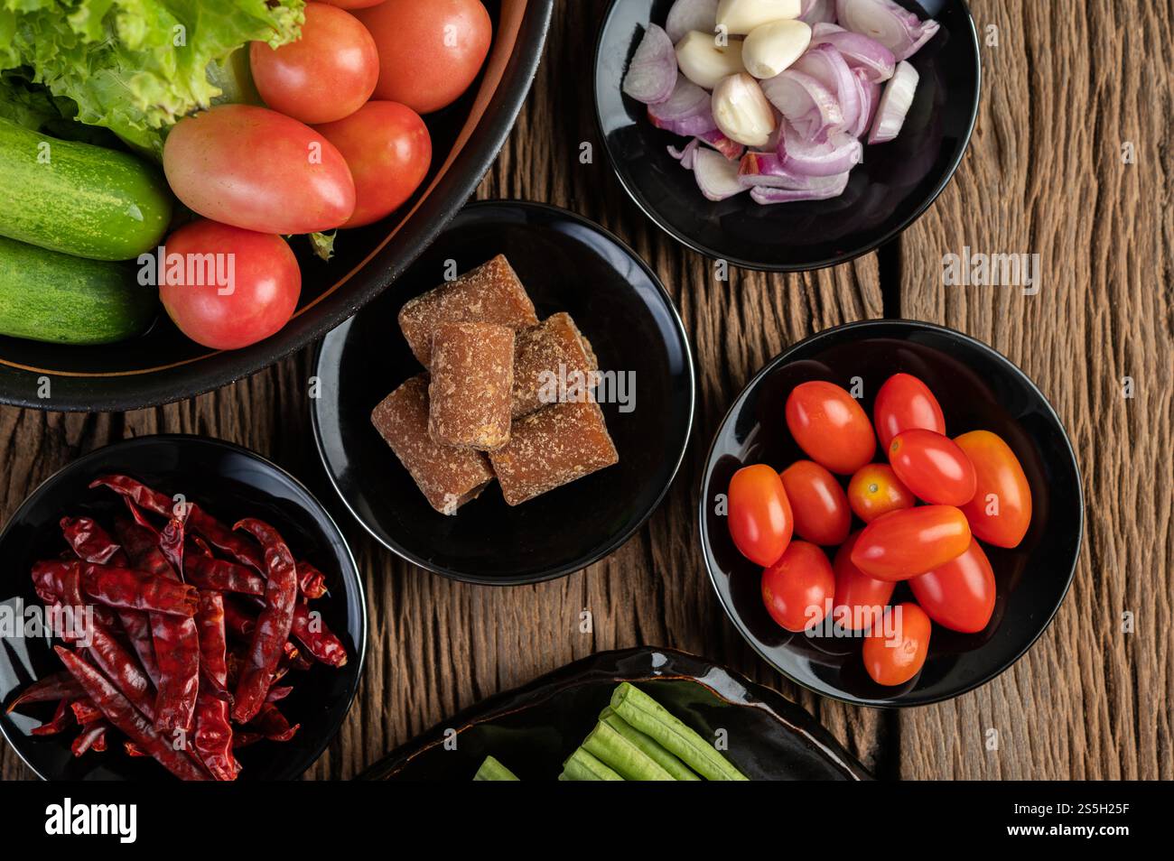 Zucchero di palma, cipolle rosse, peperoni secchi, pomodori, cetrioli, mettere i fagioli lunghi e la lattuga in un recipiente. Foto Stock
