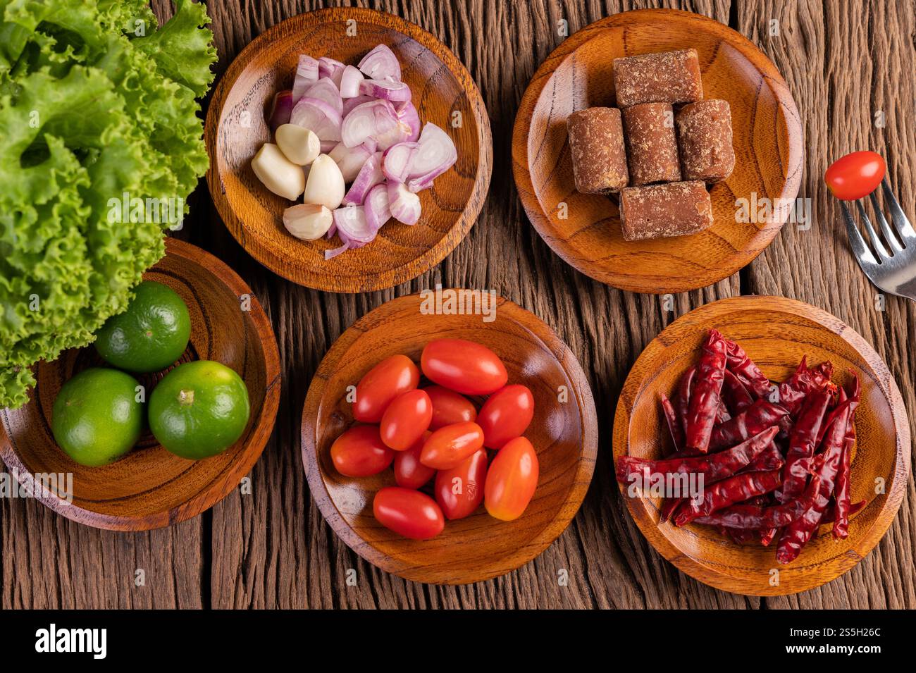 Zucchero di palma, cipolle rosse, peperoni secchi, pomodori, cetrioli, mettere i fagioli lunghi e la lattuga in un recipiente. Foto Stock