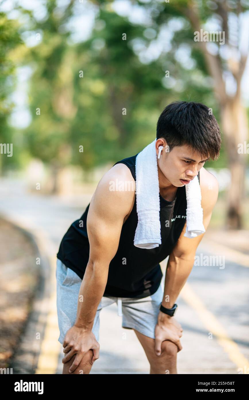 Gli uomini si alzano e si inchinano e riposano dopo l'esercizio fisico sul ciglio della strada. Messa a fuoco selettiva. Foto Stock