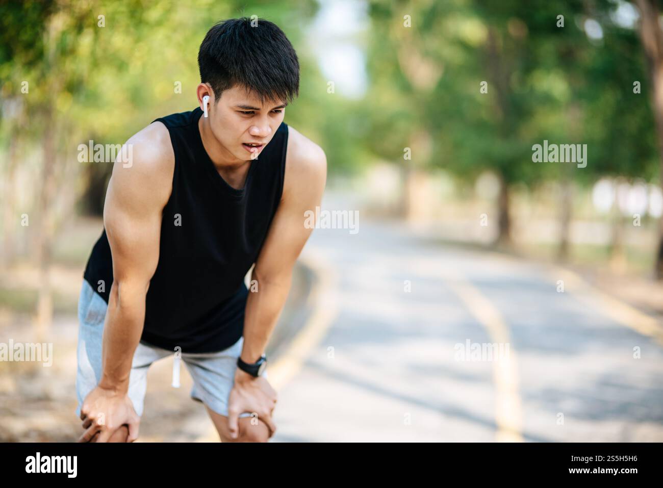 Gli uomini si alzano e si inchinano e riposano dopo l'esercizio fisico sul ciglio della strada. Messa a fuoco selettiva. Foto Stock
