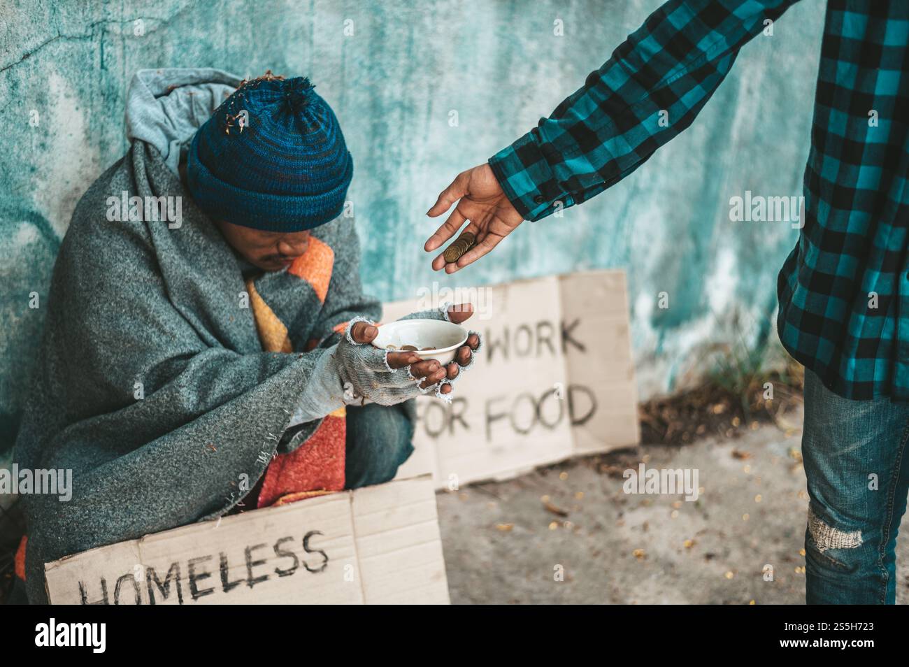 I mendicanti siedono sul lato della strada e hanno i soldi. Foto Stock