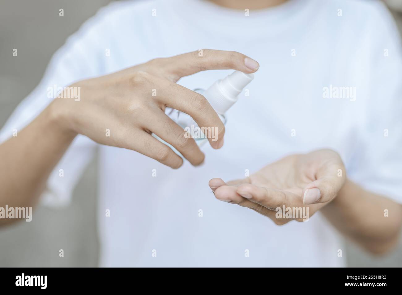 Donne che indossano camicie bianche che premono il gel per lavarsi le mani e pulire le mani. Foto Stock