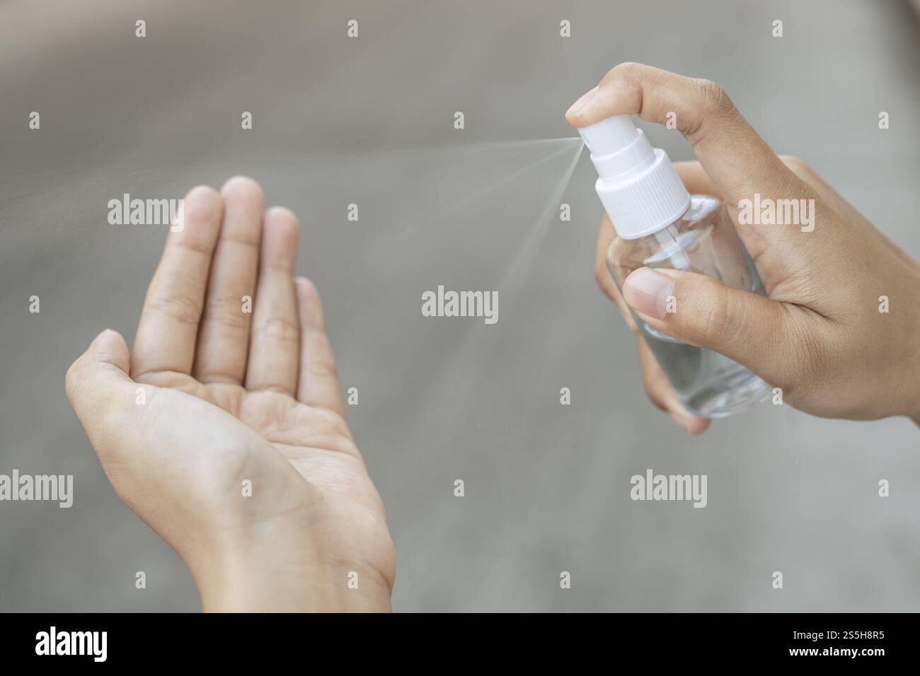 Donne che indossano camicie bianche che premono il gel per lavarsi le mani e pulire le mani. Foto Stock
