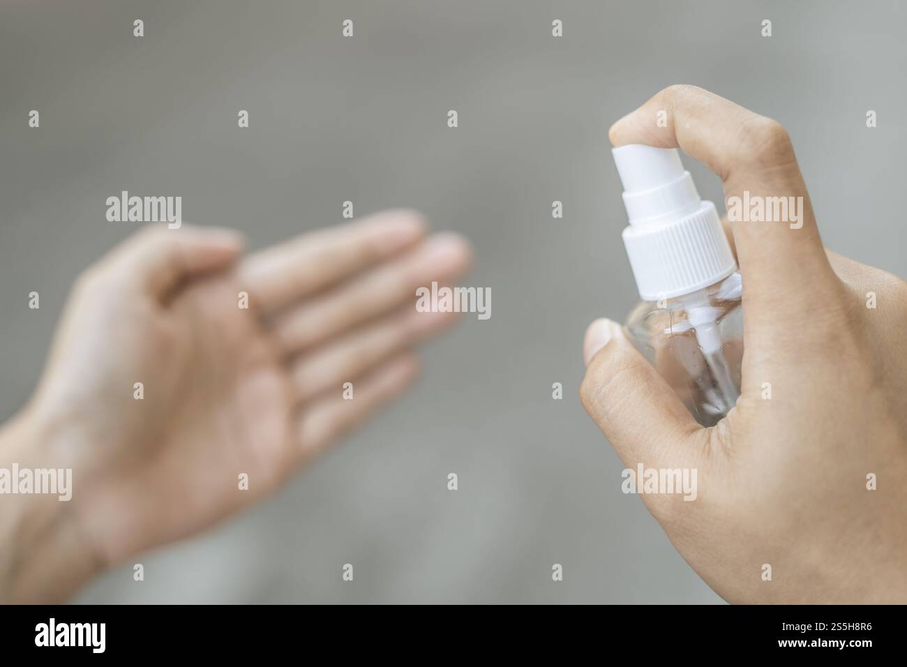 Donne che indossano camicie bianche che premono il gel per lavarsi le mani e pulire le mani. Foto Stock