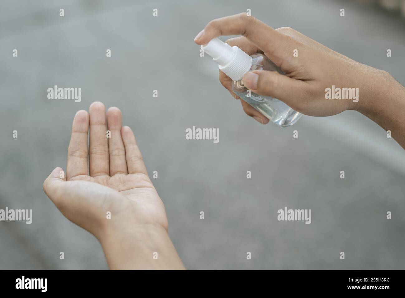 Donne che indossano camicie bianche che premono il gel per lavarsi le mani e pulire le mani. Foto Stock
