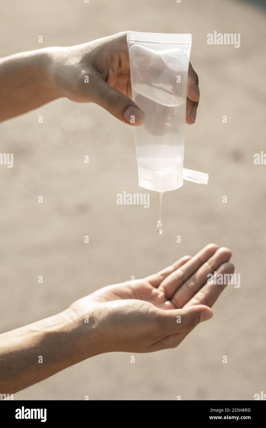 Donne che indossano camicie bianche che premono il gel per lavarsi le mani e pulire le mani. Foto Stock