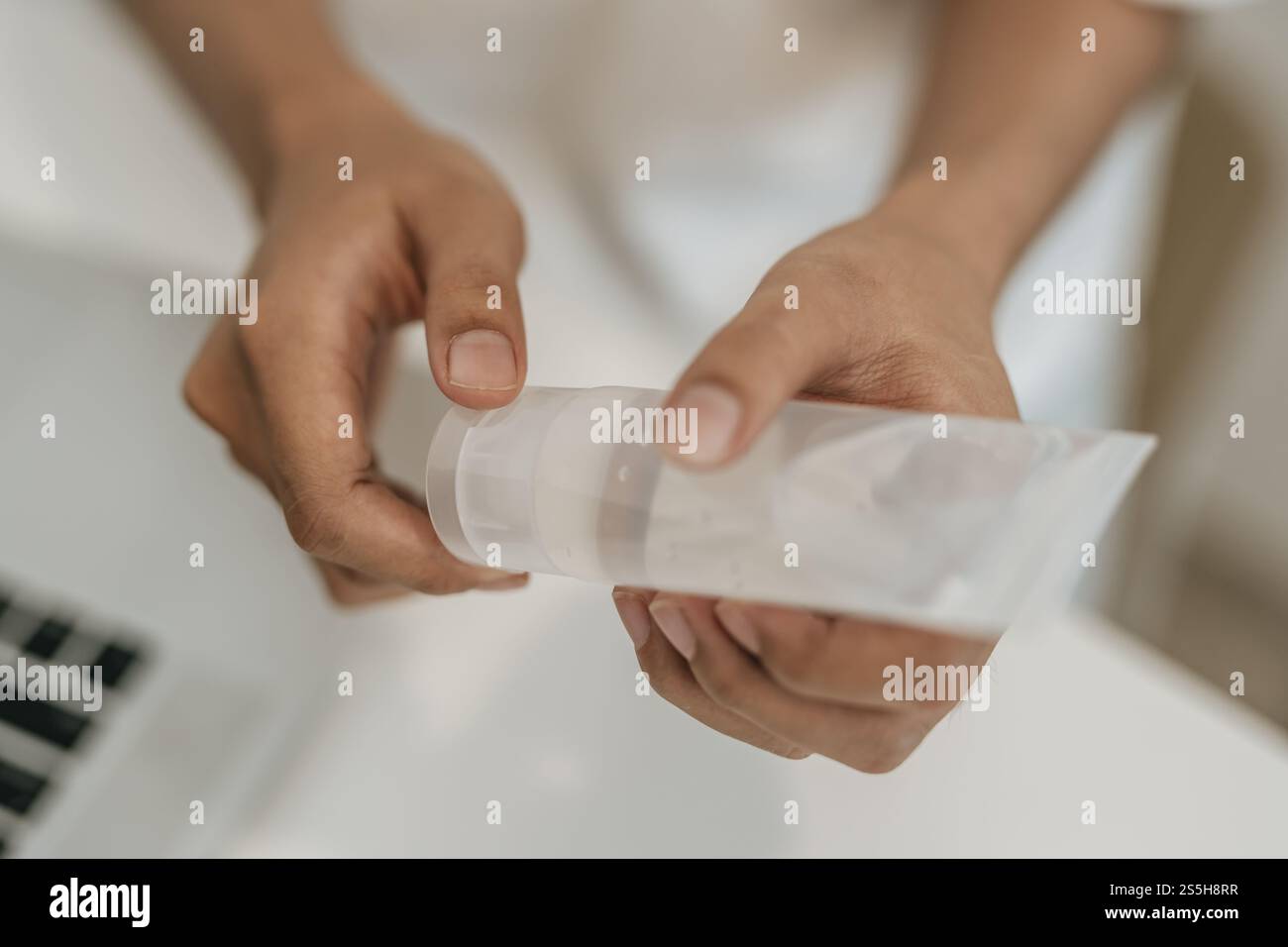 Donne che indossano camicie bianche che premono il gel per lavarsi le mani e pulire le mani. Foto Stock