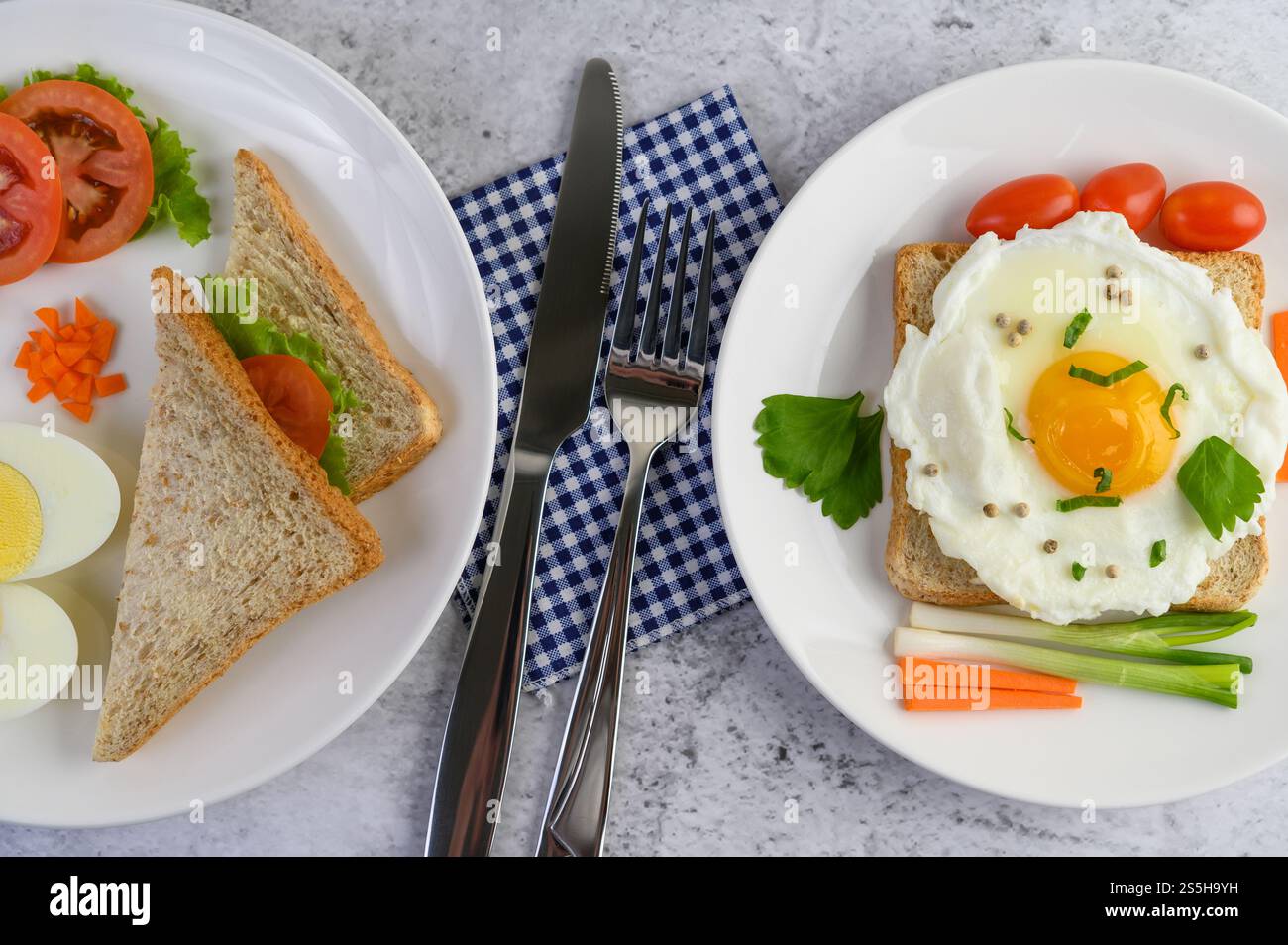 Un uovo fritto adagiato su un toast, ricoperto di semi di pepe con carote e cipollotti. Foto Stock