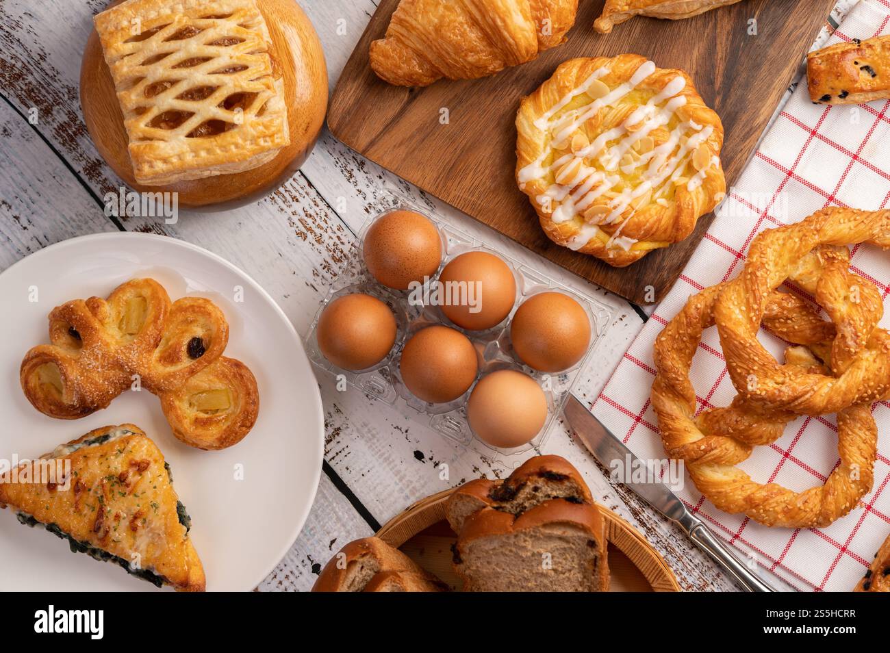 Vari tipi di pane e uova su un panno bianco rosso. Messa a fuoco selettiva. Foto Stock