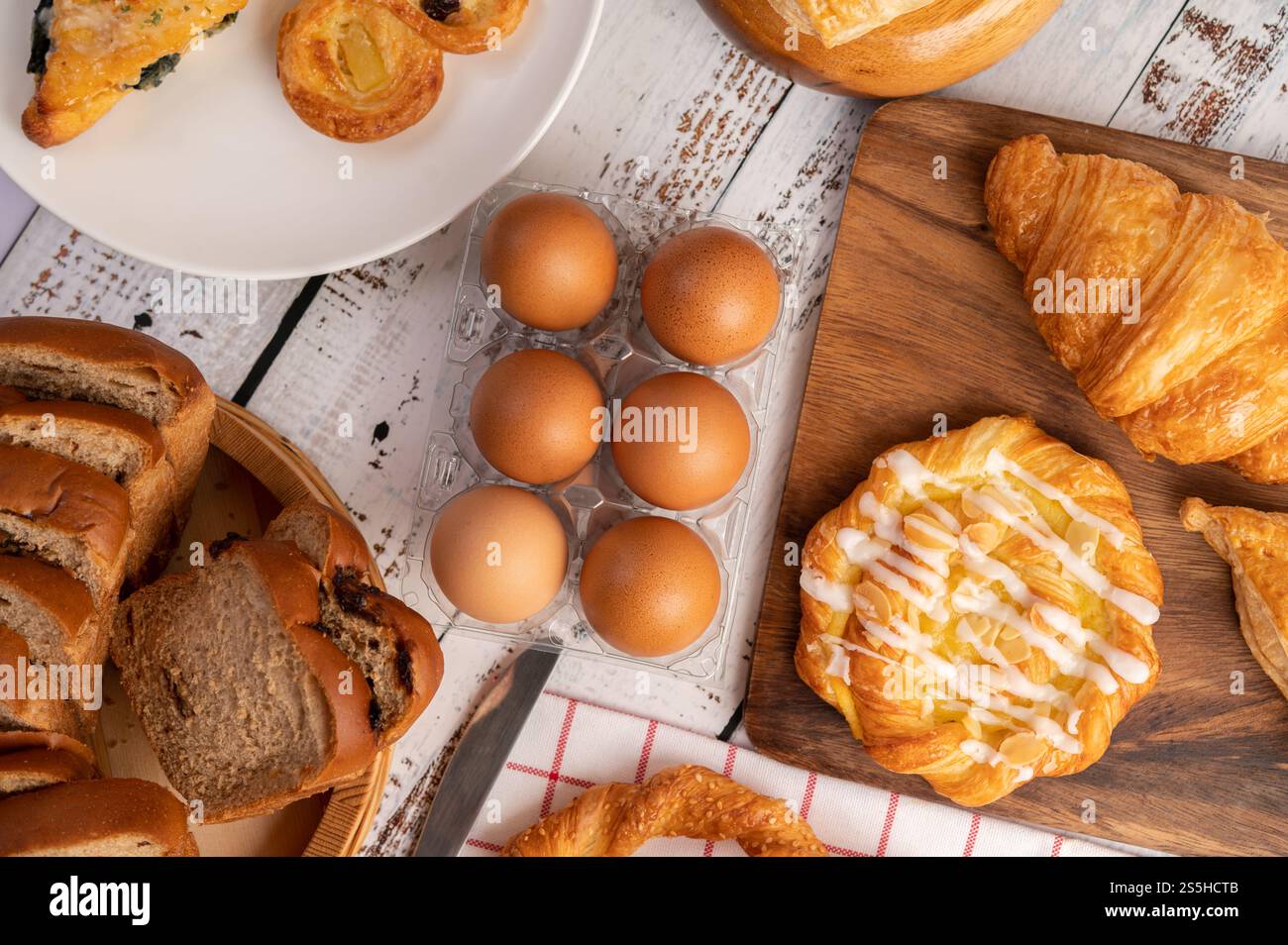 Vari tipi di pane e uova su un panno bianco rosso. Messa a fuoco selettiva. Foto Stock
