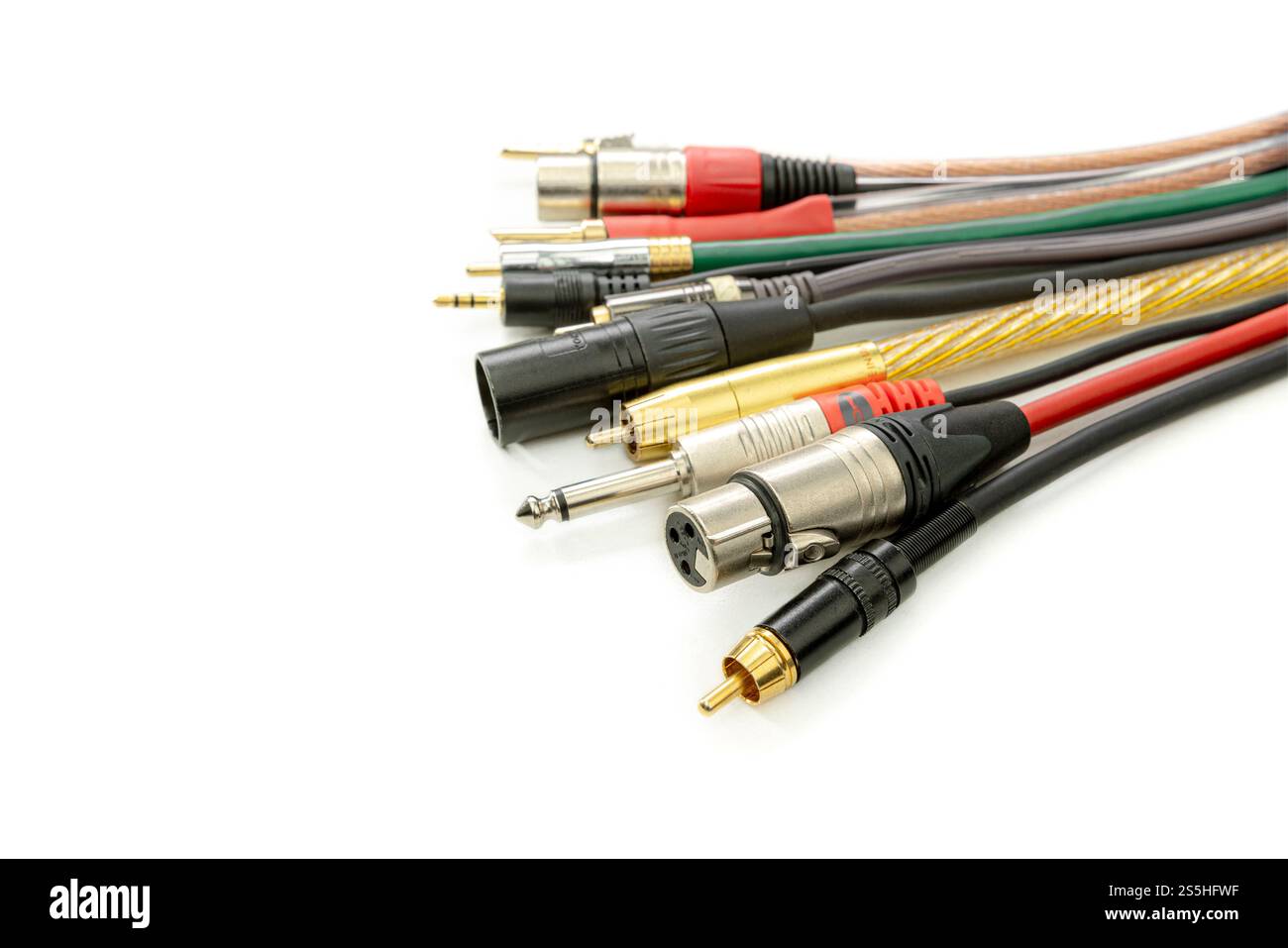 Ampia gamma di cavi e connettori audio su sfondo bianco Foto Stock