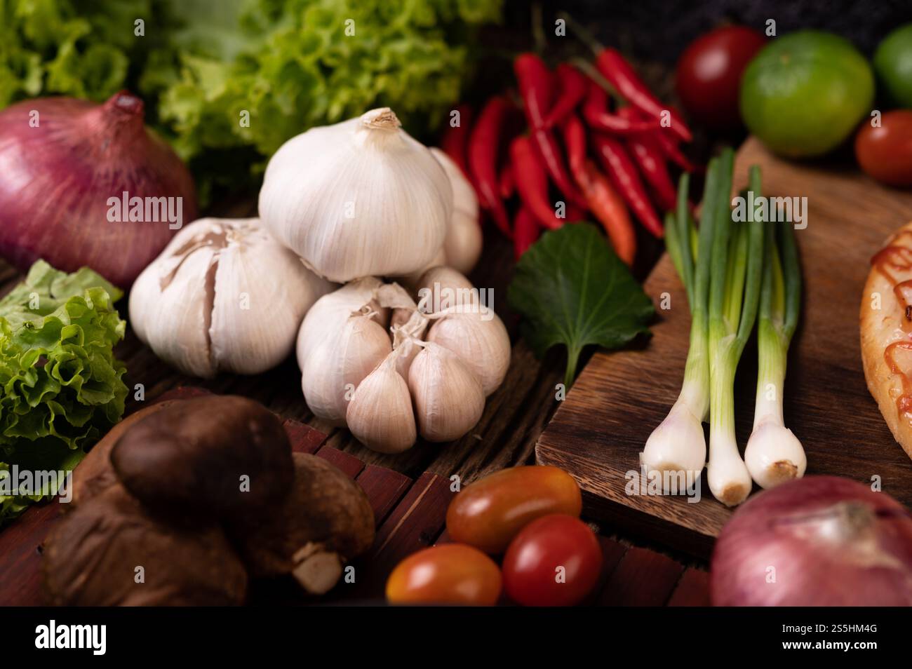 Aglio, pomodoro, funghi shiitake, peperoncino e cipolla rossa su spranghe di legno. Messa a fuoco selettiva. Foto Stock