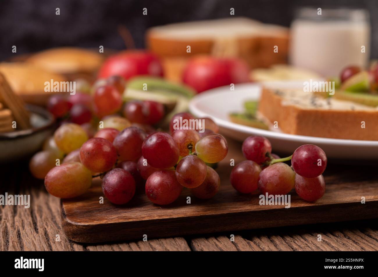 Le uve sul tagliere sulla tavola di legno. Messa a fuoco selettiva. Foto Stock