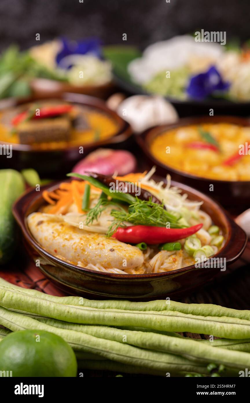 Spaghetti di riso, curry rosso con polpette, con peperoncini secchi, basilico, cetriolo e fagioli lunghi Foto Stock