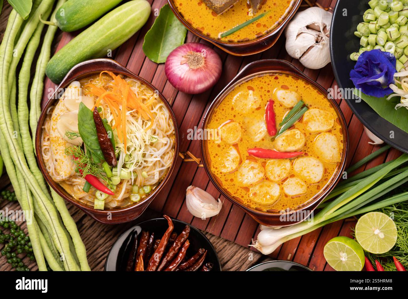 Spaghetti di riso, curry rosso con polpette, con peperoncini secchi, basilico, cetriolo e fagioli lunghi Foto Stock