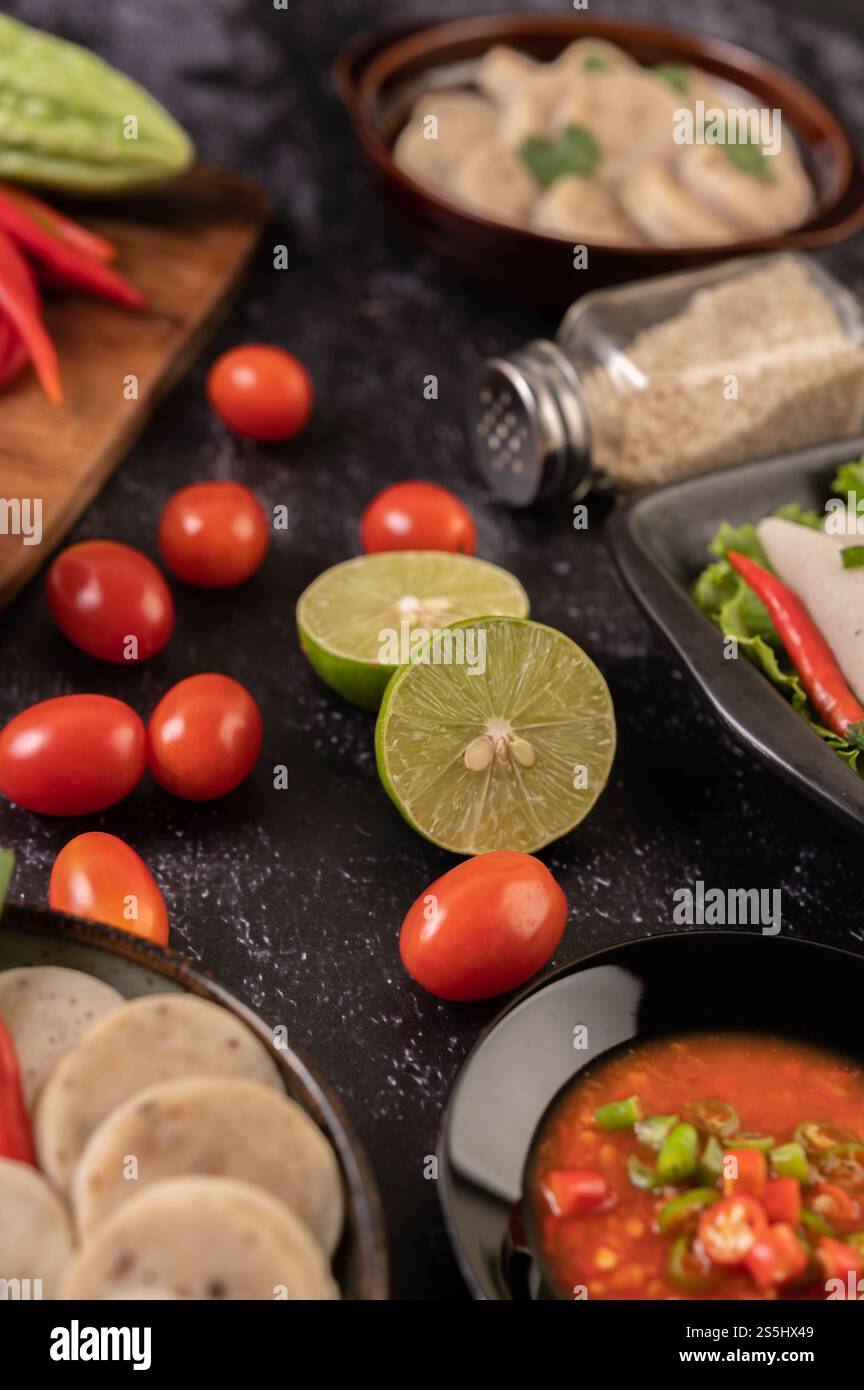 Gli ingredienti utilizzati per l'insalata includono pomodori, peperoni, lime e buccia amara. Foto Stock