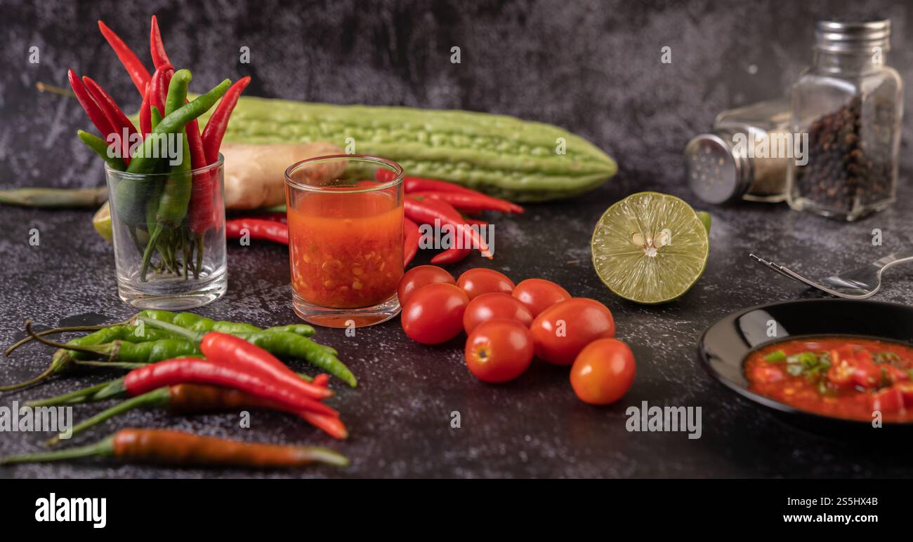 Gli ingredienti utilizzati per l'insalata includono pomodori, peperoni, lime e buccia amara. Foto Stock