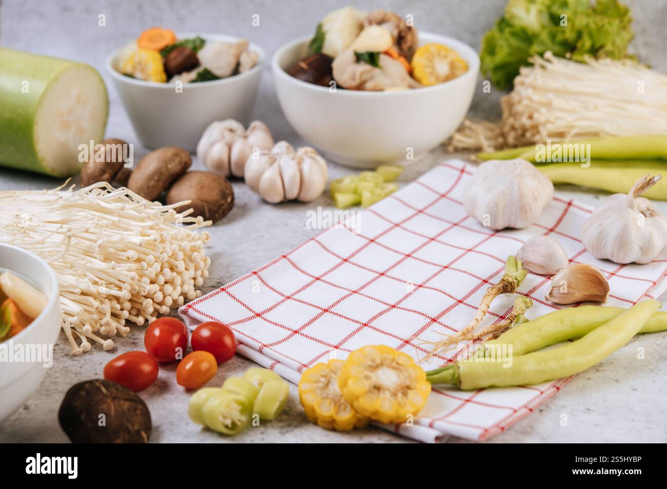 Gli ingredienti utilizzati per preparare la zuppa includono mais, funghi shiitake, pomodori, funghi ad ago, peperoncino, e aglio. Foto Stock