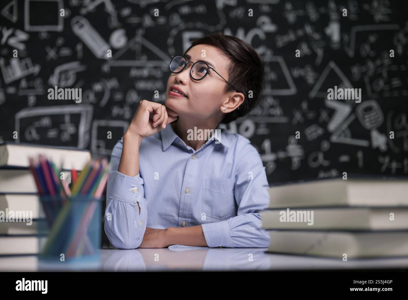 L'insegnante sedeva pensando di insegnare in classe Foto Stock