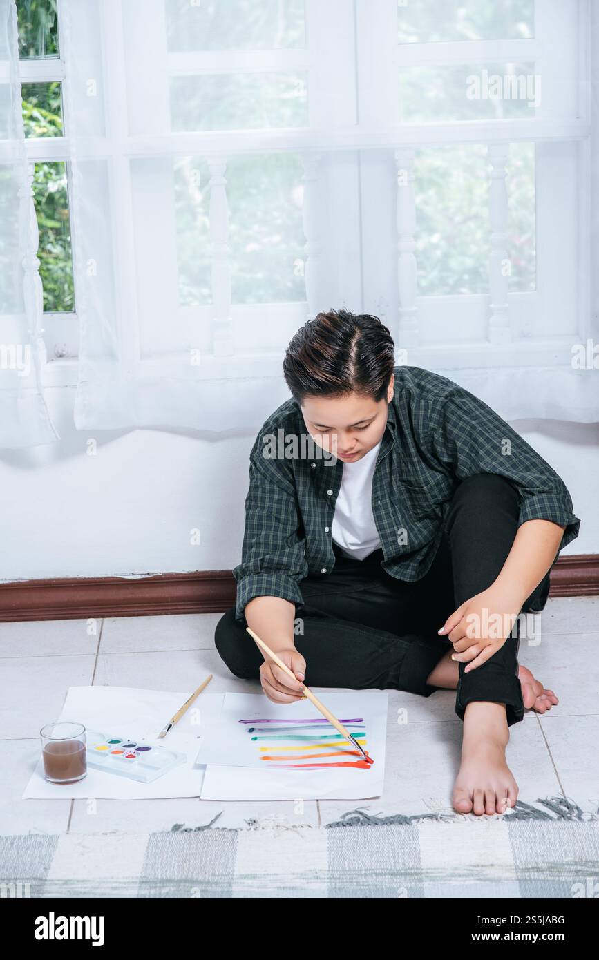 Le donne disegnano e dipingono l'acqua sulla carta. Foto Stock