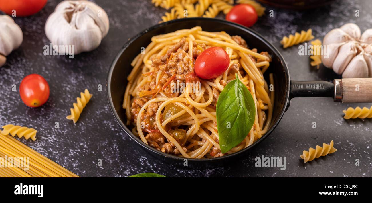 Spaghetti saltati in padella con pomodori e basilico Foto Stock
