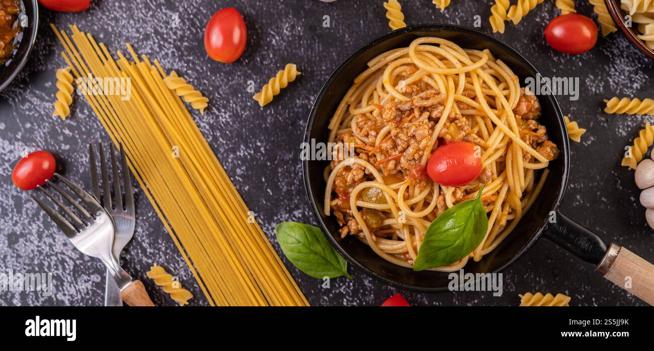 Spaghetti saltati in padella con pomodori e basilico Foto Stock