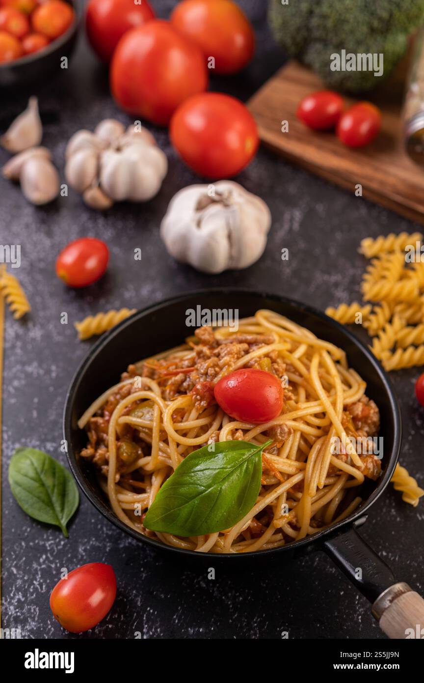 Spaghetti saltati in padella con pomodori e basilico Foto Stock