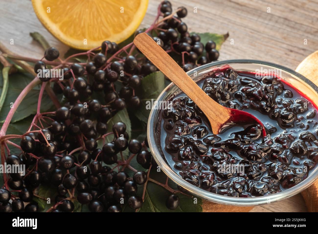 Chiudere la marmellata di ederberry, le bacche e le foglie fresche e il limone. concetto di piante medicinali. Foto Stock