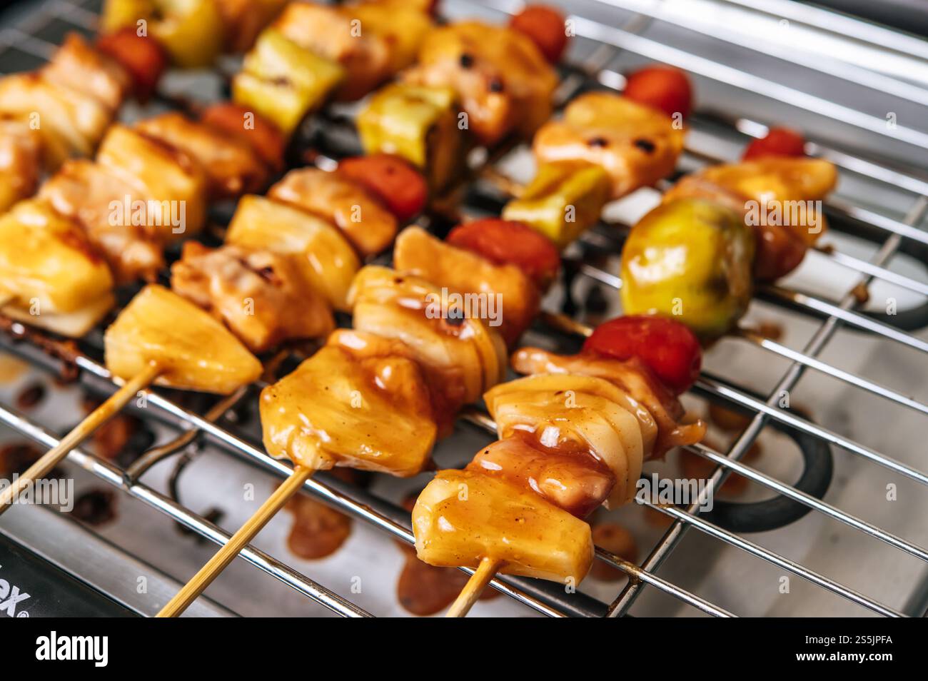Barbecue con una varietà di carni, completo di pomodori e peperoni. Foto Stock