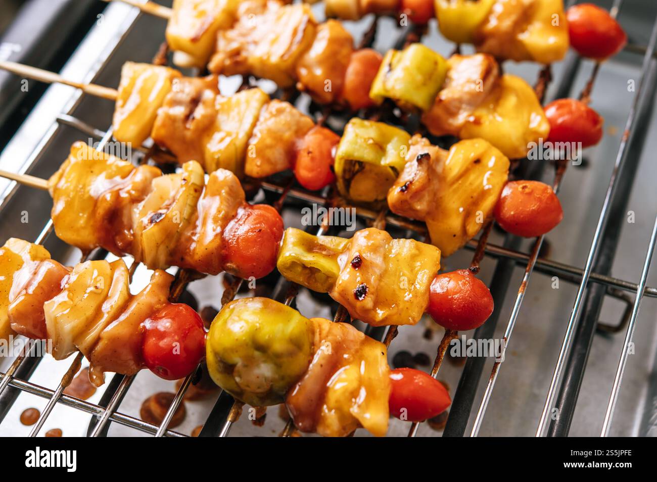 Barbecue con una varietà di carni, completo di pomodori e peperoni. Foto Stock
