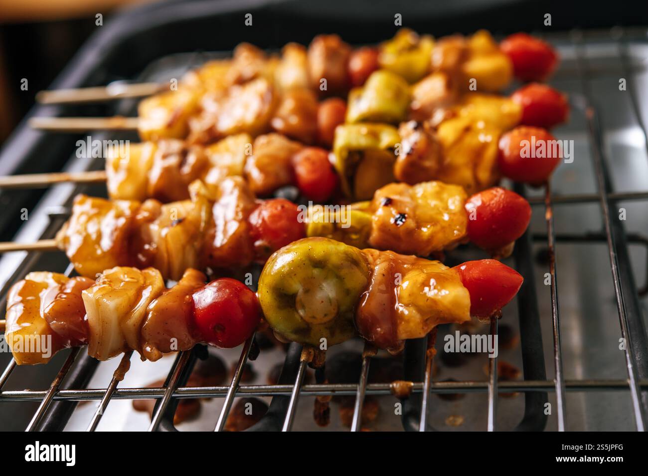 Barbecue con una varietà di carni, completo di pomodori e peperoni. Foto Stock