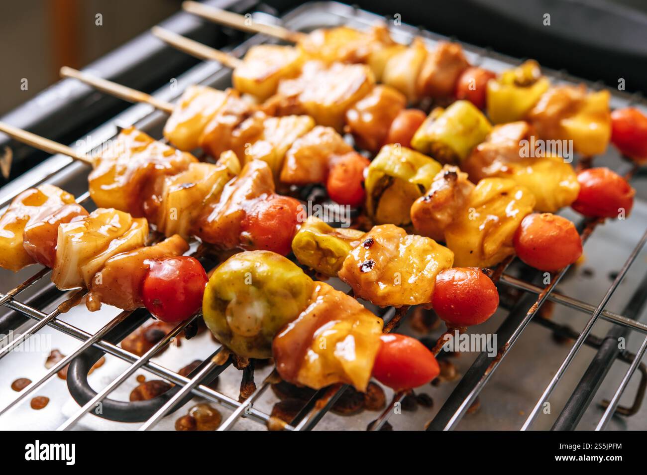 Barbecue con una varietà di carni, completo di pomodori e peperoni. Foto Stock