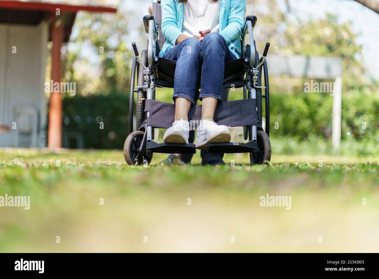 Giovane donna asiatica in sedia a rotelle con pensiero positivo Foto Stock