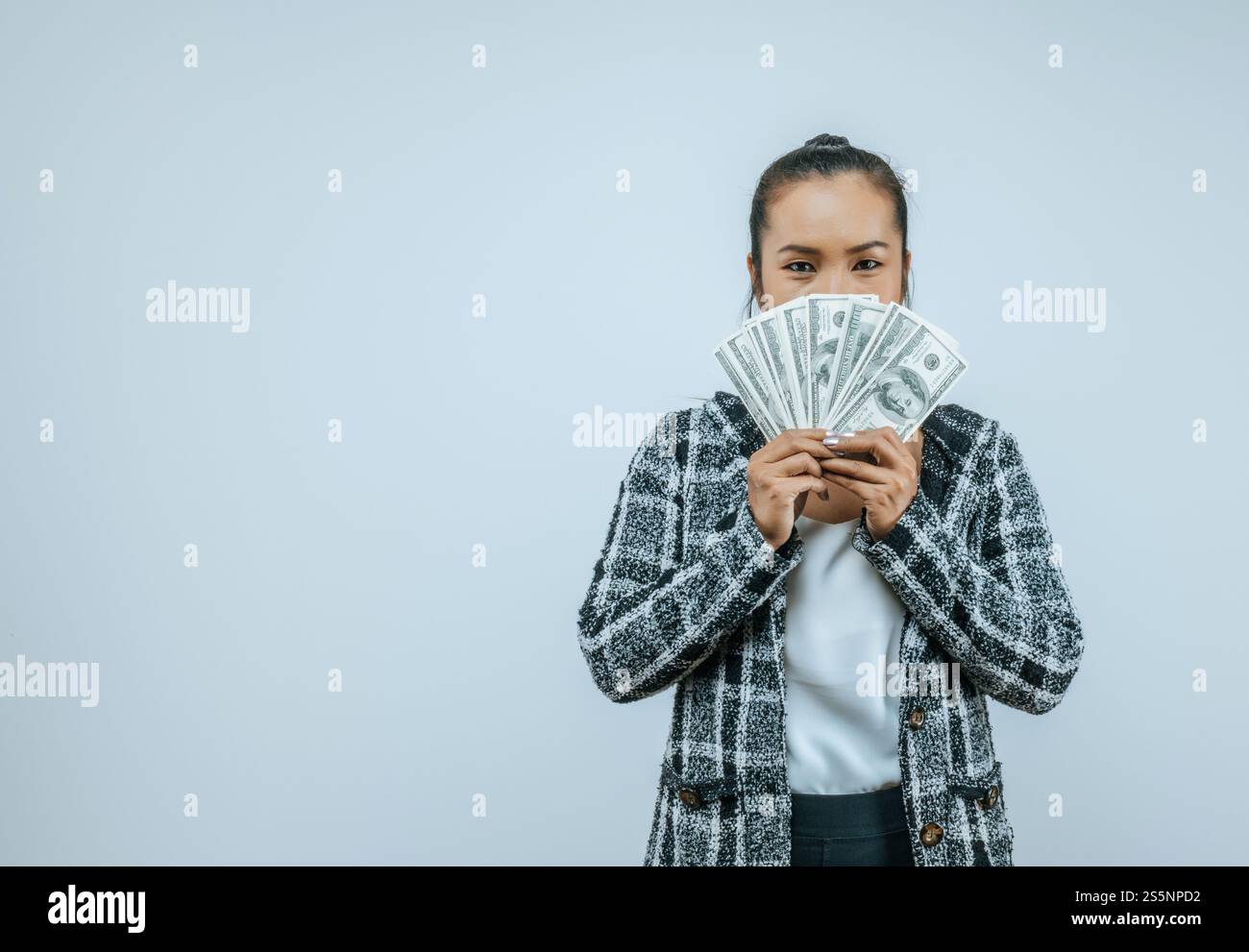 Ritratto di una donna asiatica di successo che tiene in mano i soldi e guarda la macchina fotografica, in piedi sullo sfondo in studio con spazio di copia. Financal e Make Foto Stock
