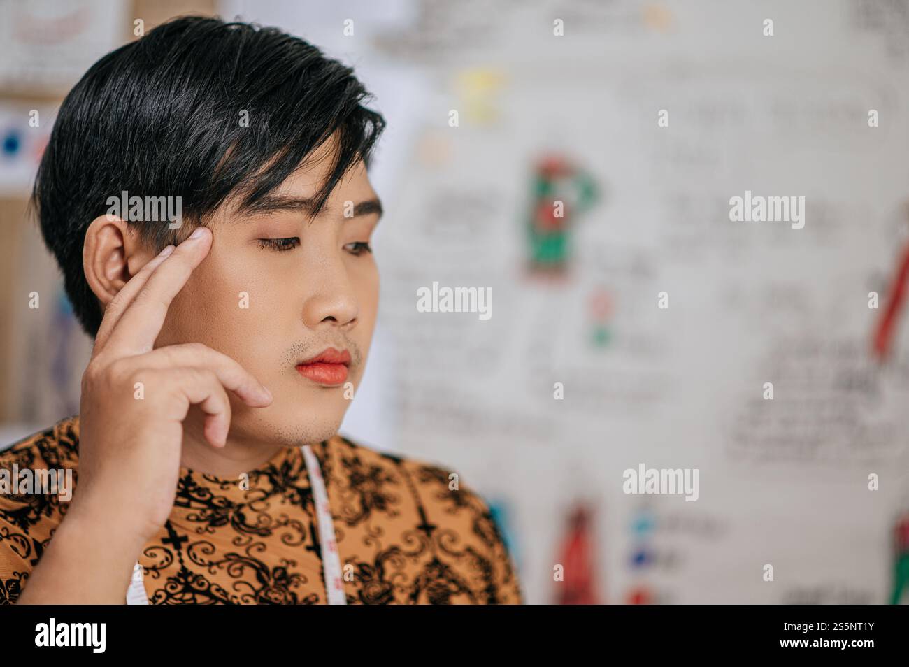 Primo piano del giovane sarto asiatico professionale con metro a nastro sul collo in studio. Design e concetto LGBTQ. Foto Stock Primo piano del giovane sarto asiatico professionale con metro a nastro sul collo in studio. Design e concetto LGBTQ. Foto Stock