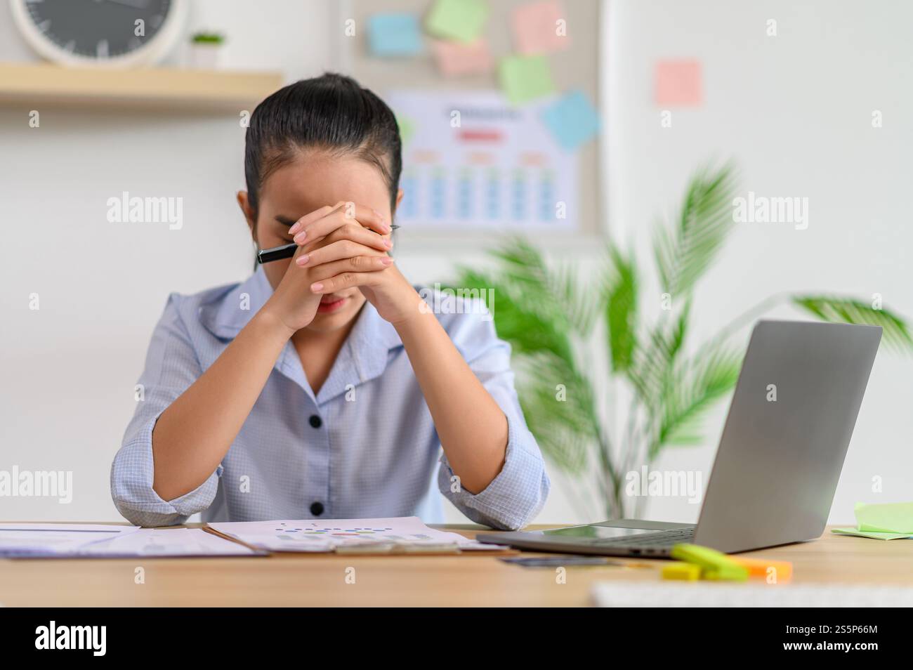 Una lavoratrice donna utilizza un notebook e pensa di risolvere i problemi in ufficio. Foto Stock