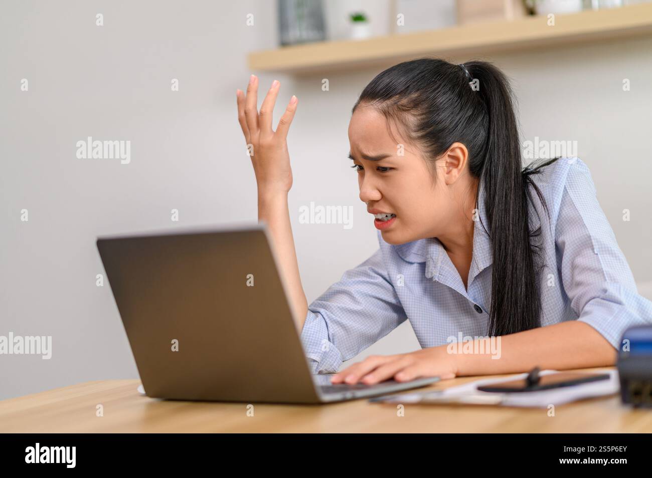 Una lavoratrice donna utilizza un notebook e pensa di risolvere i problemi in ufficio. Foto Stock