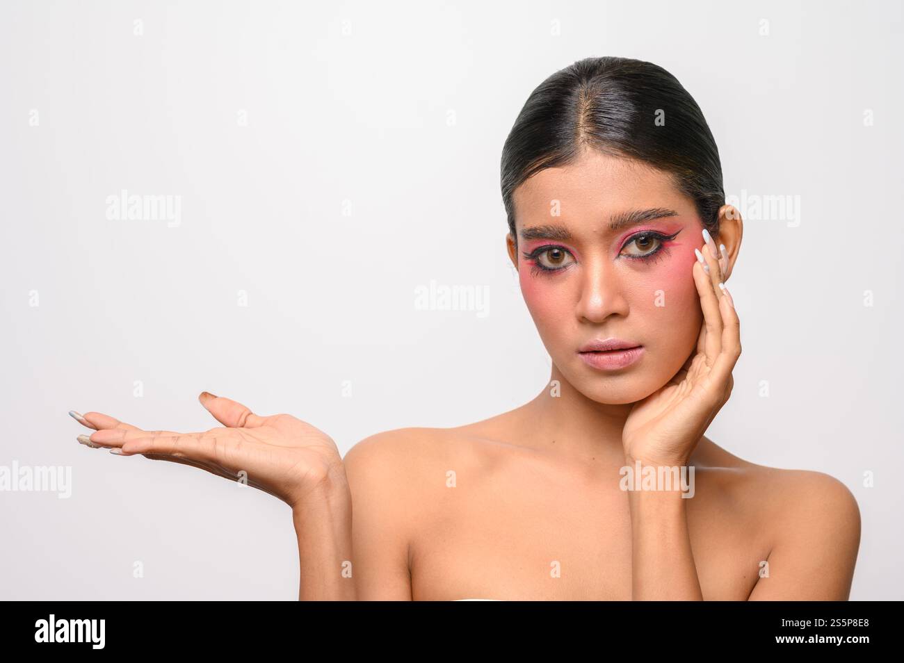 La donna si è messa il trucco rosa e ha messo la mano sul viso. Isolato su sfondo bianco Foto Stock