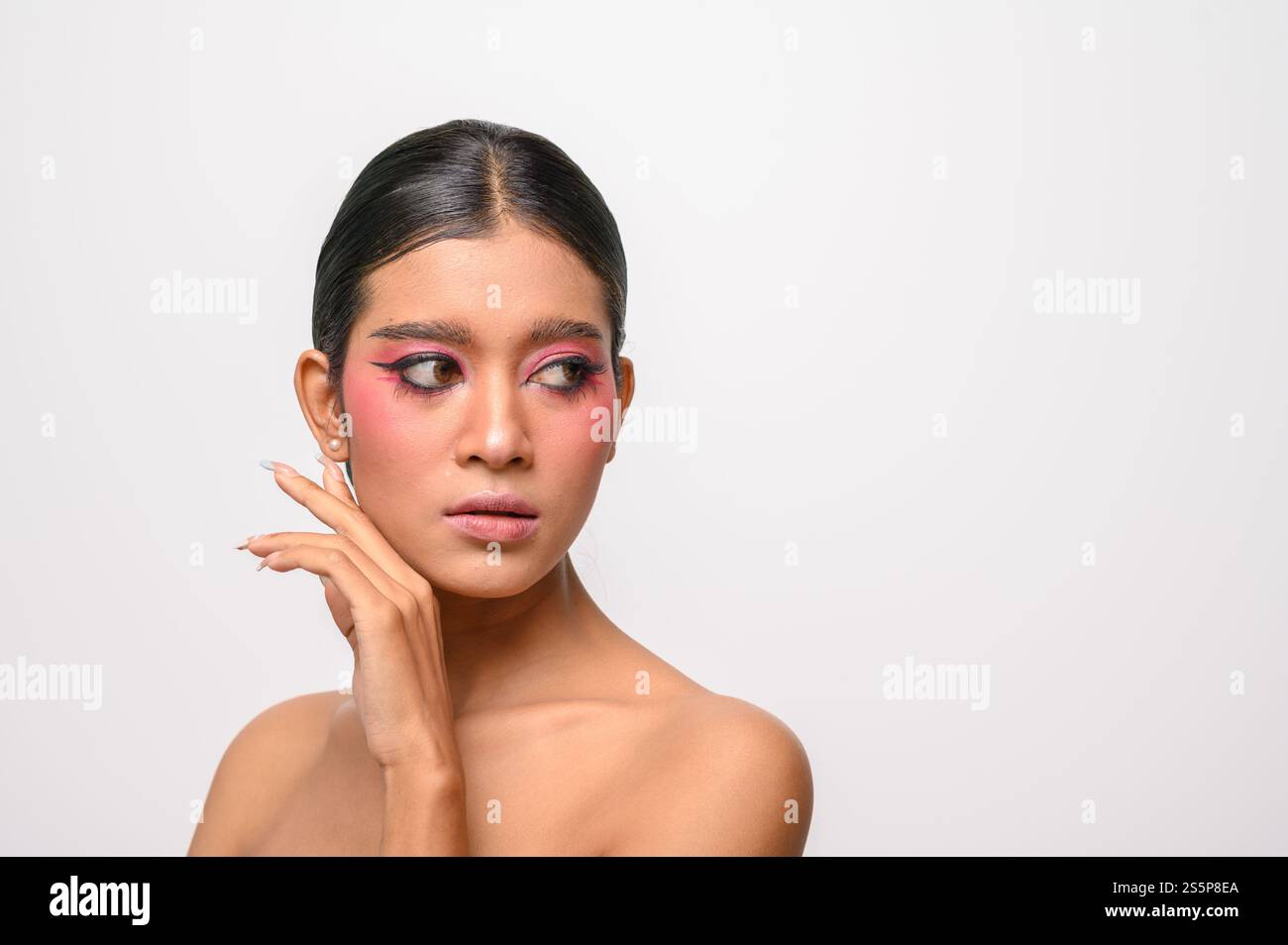 La donna si è messa il trucco rosa e ha messo la mano sul viso. Isolato su sfondo bianco Foto Stock
