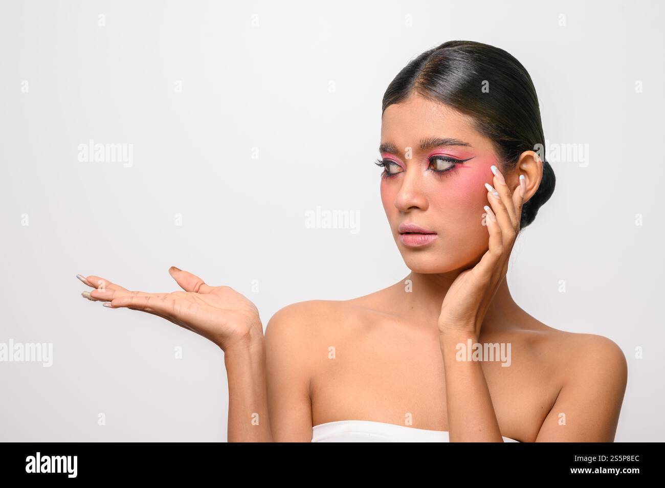 La donna si è messa il trucco rosa e ha messo la mano sul viso. Isolato su sfondo bianco Foto Stock