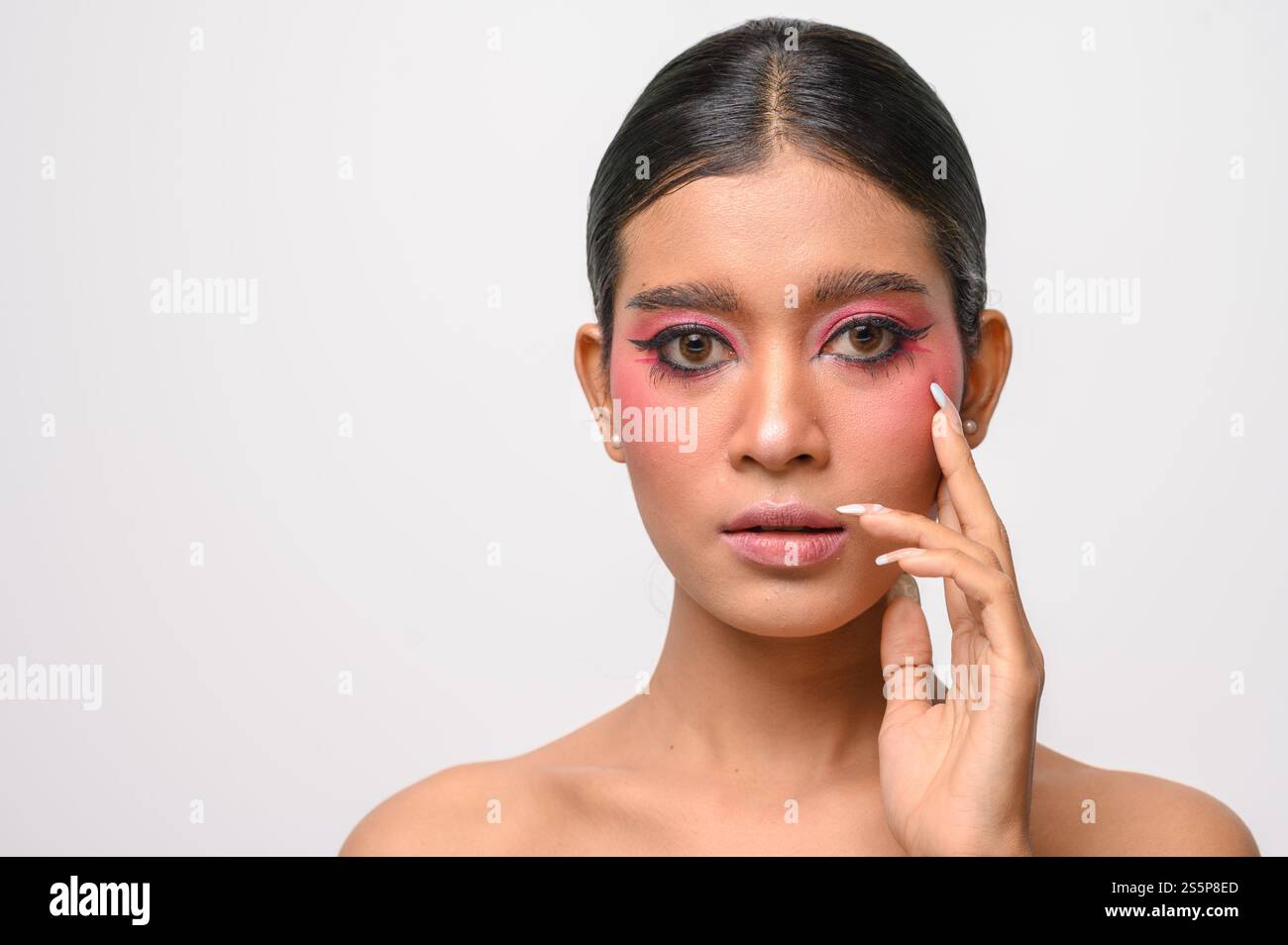 La donna si è messa il trucco rosa e ha messo la mano sul viso. Isolato su sfondo bianco Foto Stock