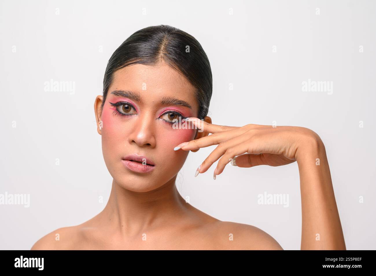 La donna si è messa il trucco rosa e ha messo la mano sul viso. Isolato su sfondo bianco Foto Stock