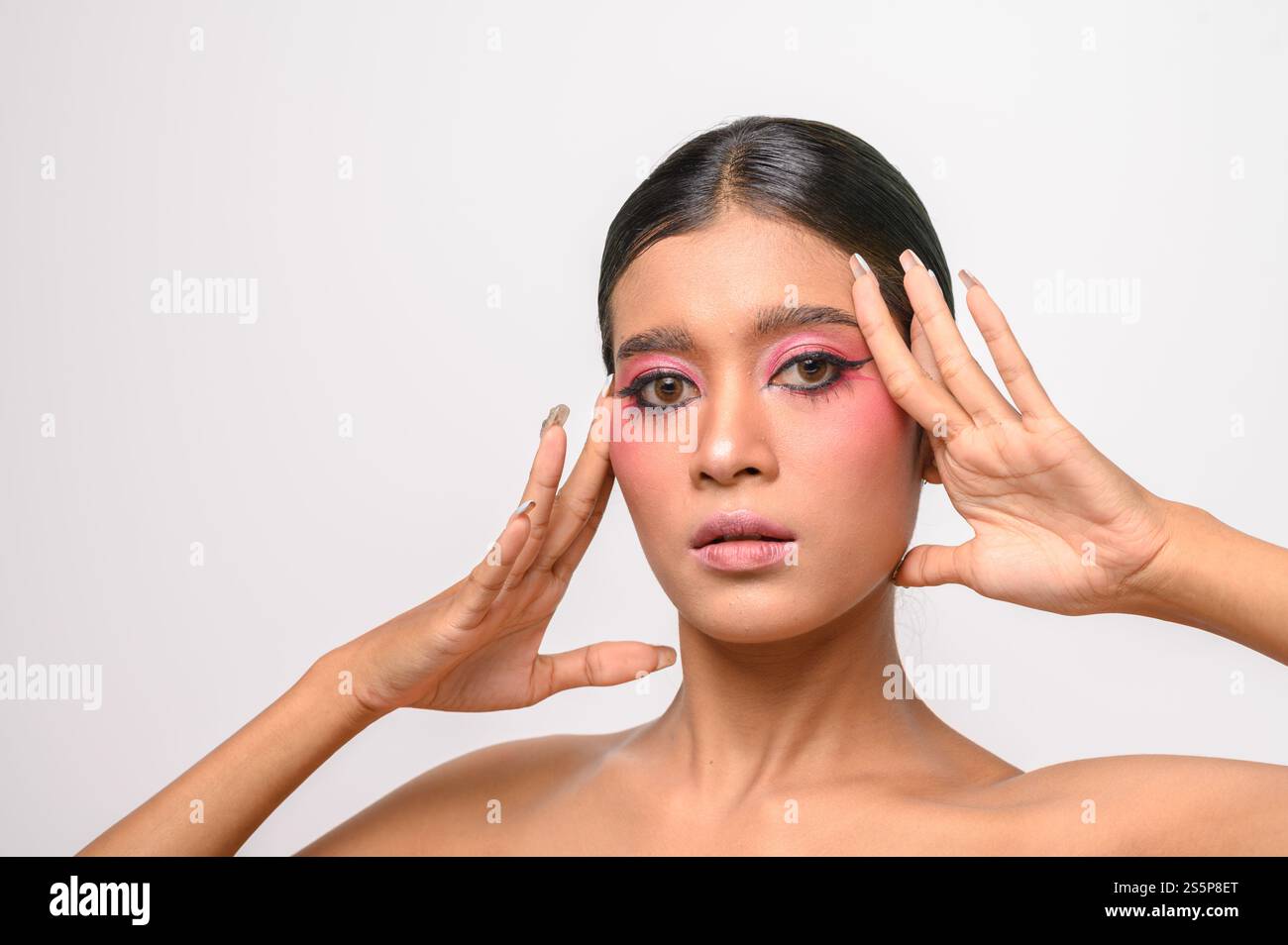 La donna si è messa il trucco rosa e ha messo la mano sul viso. Isolato su sfondo bianco Foto Stock