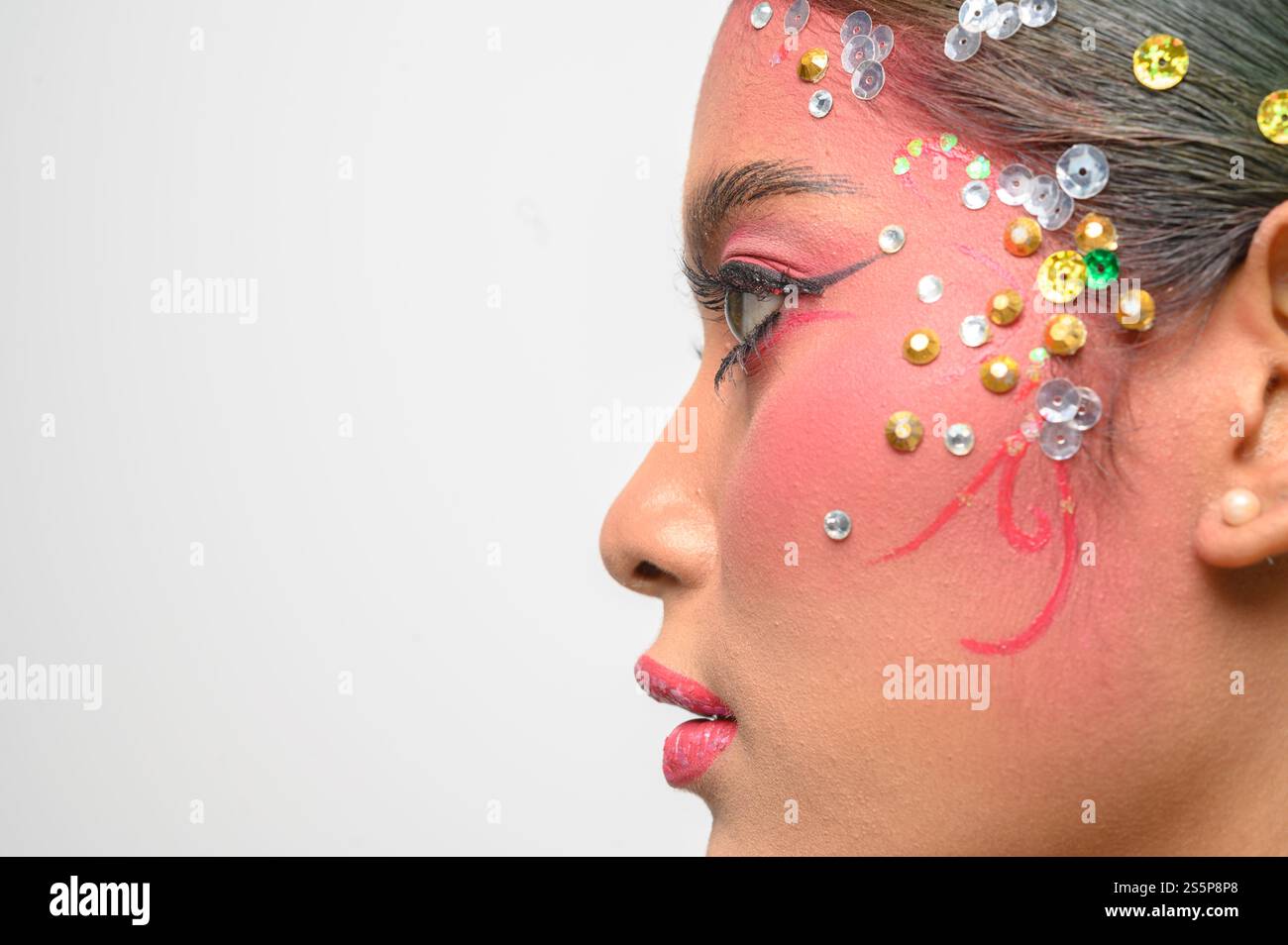 Donna che indossa trucco e decorazioni rosa sul viso. Isolato su sfondo bianco Foto Stock