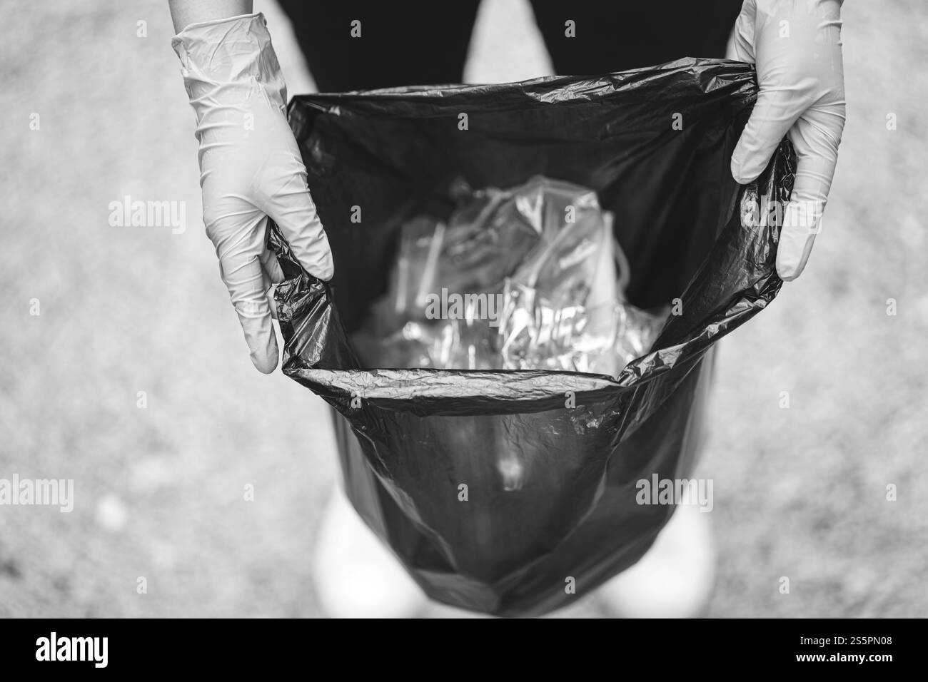 Donatrice volontaria che tiene a mano il sacchetto nero della spazzatura e la spazzatura della bottiglia di plastica per il riciclaggio per la pulizia nel parco volontariato concetto di riutilizzo e Foto Stock