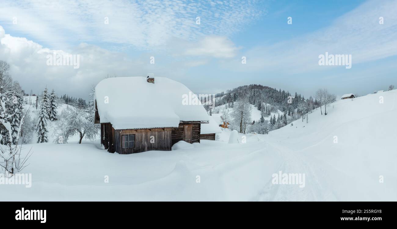 Rustico casa in legno in cumuli di neve sulle piste da sci in inverno ucraino Montagne dei Carpazi in nuvoloso meteo. Foto Stock