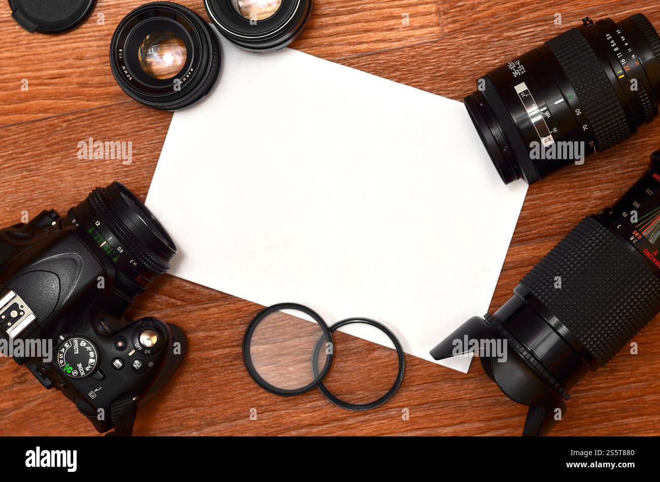 STILL Life con un set di fotografi professionisti. Fotocamera con molti obiettivi e accessori fotografici su una superficie in legno marrone con un sito per Foto Stock